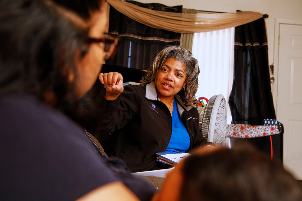 Two adults with a dark skin tone sitting in a living room