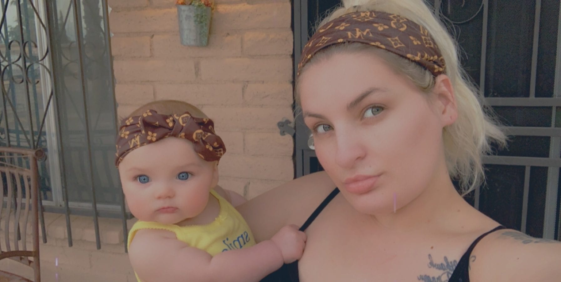 An adult is taking a selfie with a baby both with a light skin tone, using a digital filter.